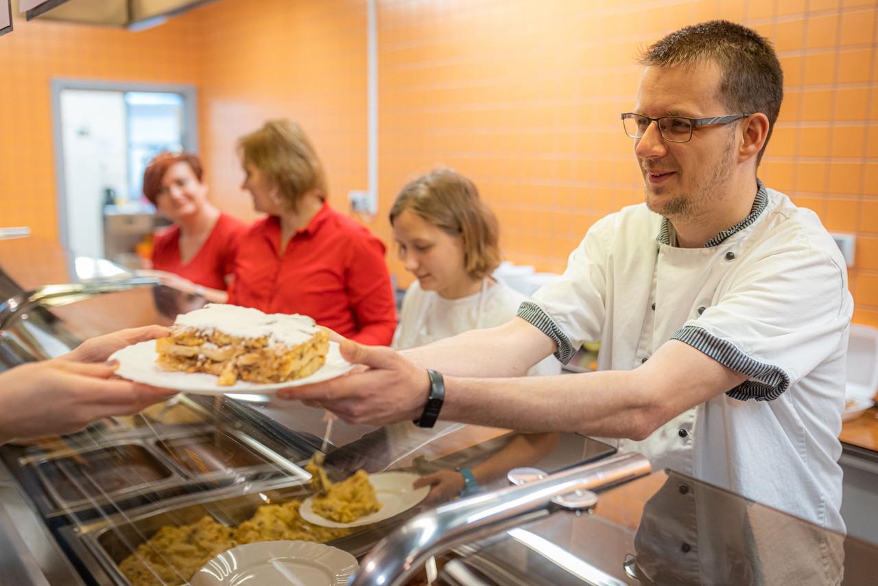 Muž vydávající jídlo.